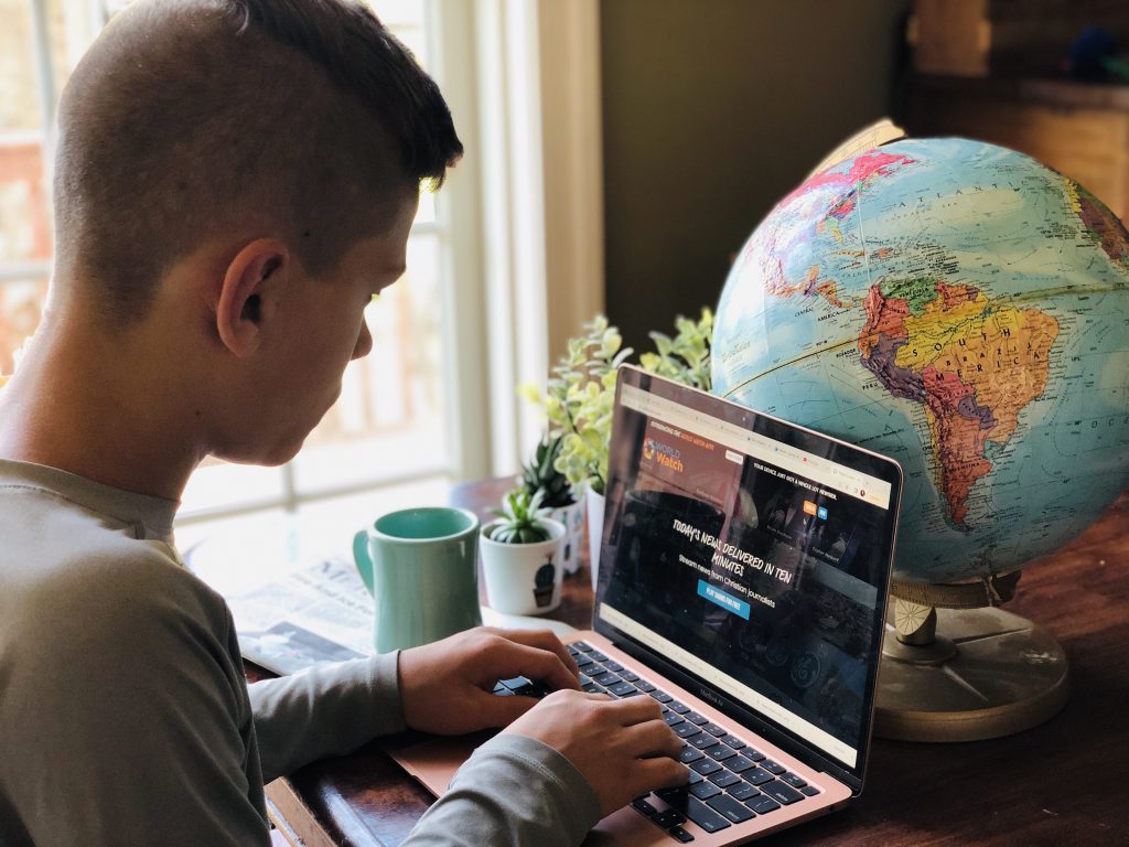 globe, boy typing on a computer