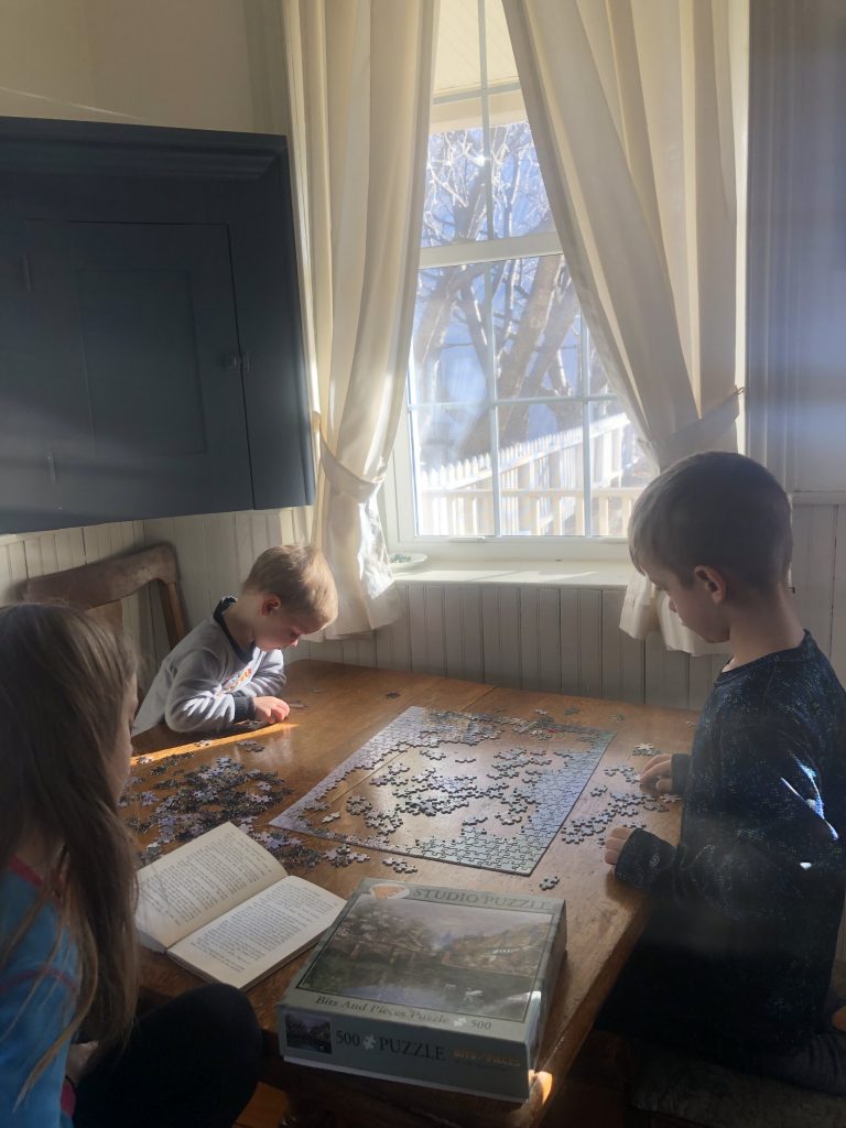 three kids doing a puzzle