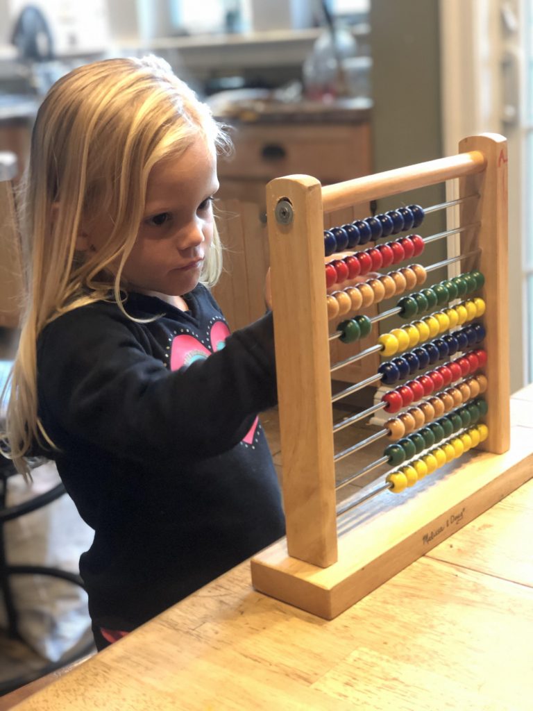 girl counting on an abacus