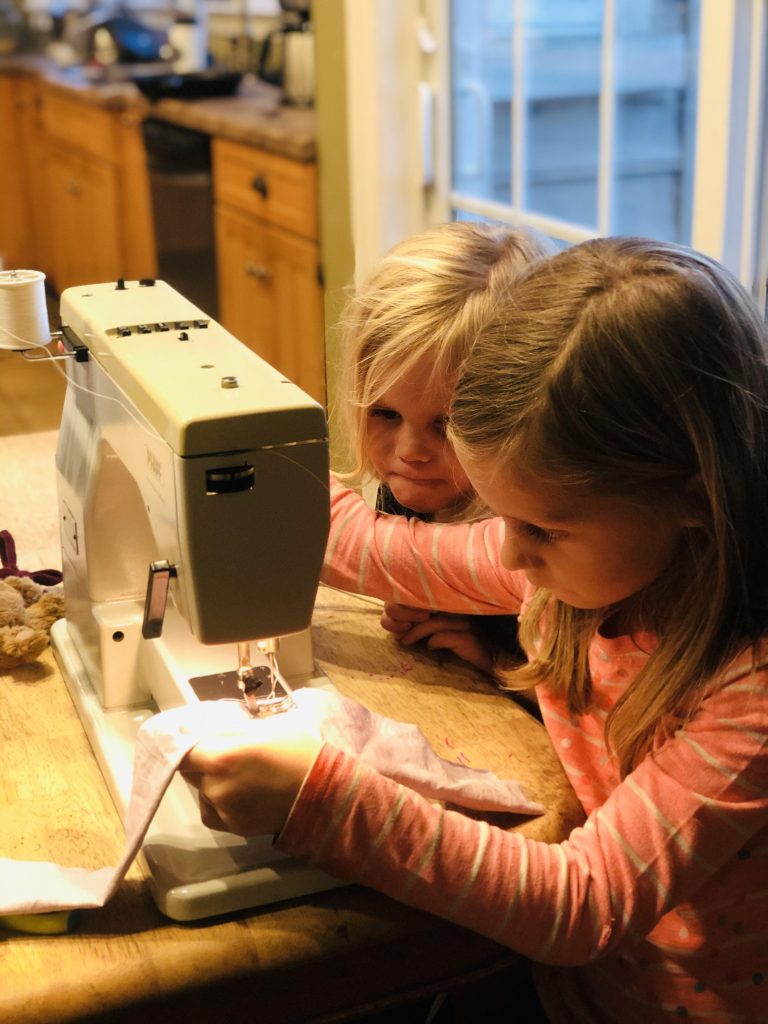 two girls sewing on sewing machine